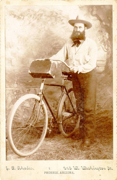 Dr. Fenn J Hart posing next to a bicycle in Phoenix, Arizona