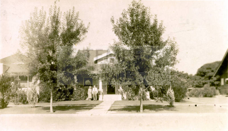 Distant photo of Dr. Fenn J Hart and Rosa Brown Hart in front of their Phoenix home
