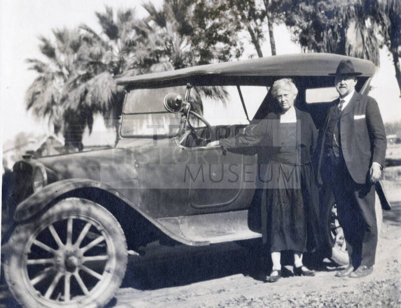 Dr. Fenn J Hart standing outside with his wife Mrs. Rosa Brown Hart in front of his Dodge