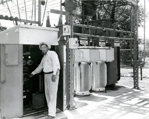 Man Standing by Electric Panel at Power Plant