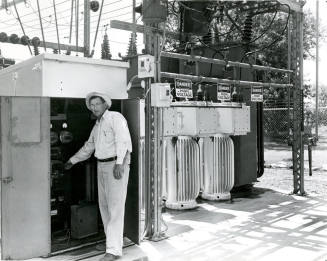 Man Standing by Electric Panel at Power Plant