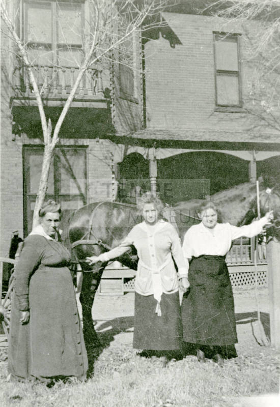 Three women standing in front of Petersen house
