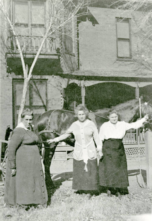 Three women standing in front of Petersen house