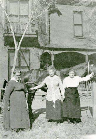 Three women standing in front of Petersen house