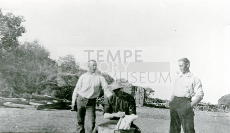 Three men standing and sitting on Petersen property
