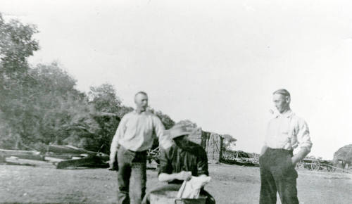 Three men standing and sitting on Petersen property