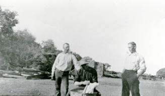 Three men standing and sitting on Petersen property