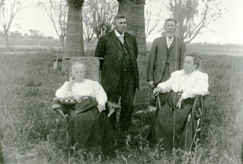 Two couples standing and sitting on Petersen property