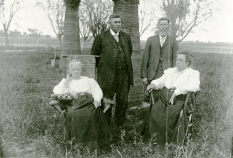 Two couples standing and sitting on Petersen property