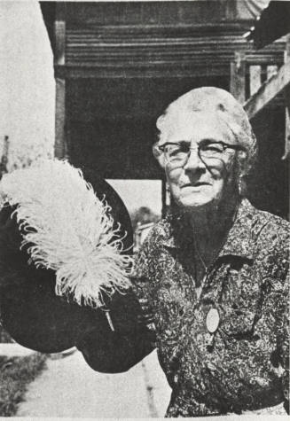 Stella Hackett Standing Holding Her Hat