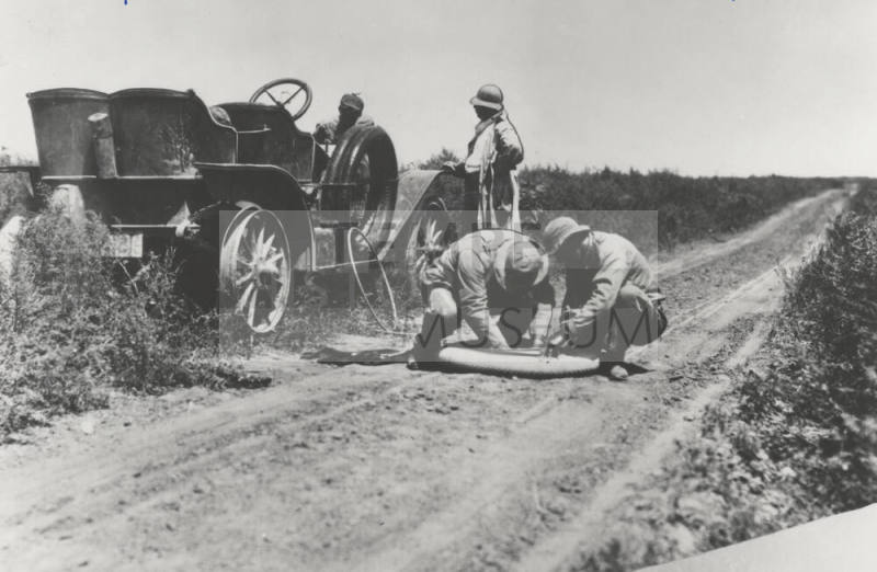 Two Men Repair a Circa 1920 Car Tire