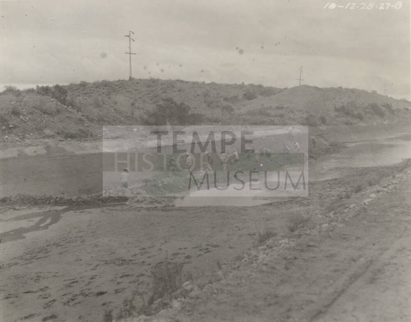 Photo- men repairing lining of Great Eastern Canal in front of desert wash