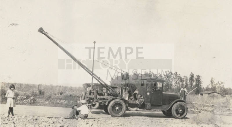 Photo- people standing near commercial Dodge truck with hoist