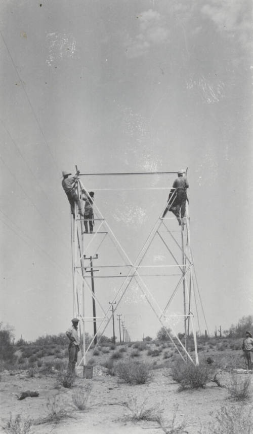 Photo- construction crew erecting a line tower