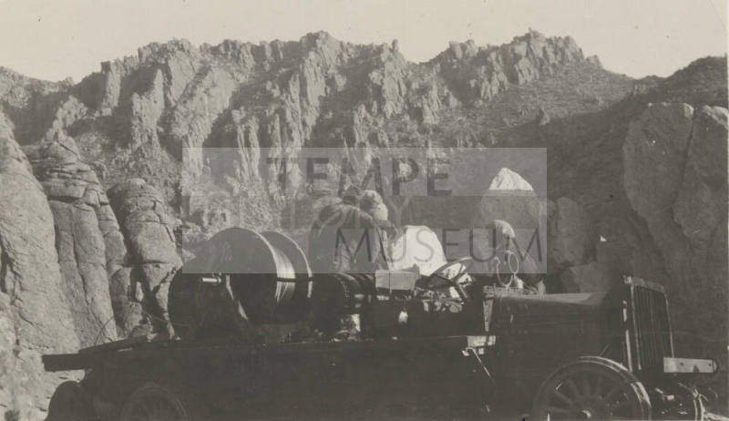 Workers stringing wire from truck in mountains