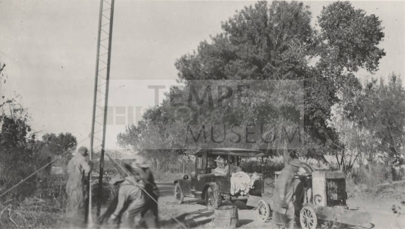 Workers setting steel poles with cement