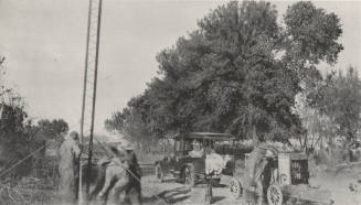 Workers setting steel poles with cement
