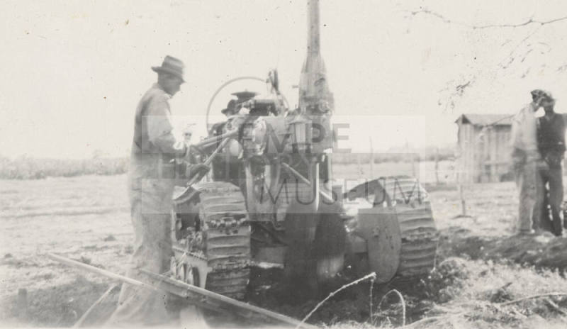Man operating a pole hole digging machine