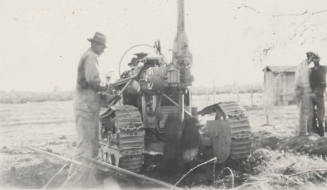 Man operating a pole hole digging machine