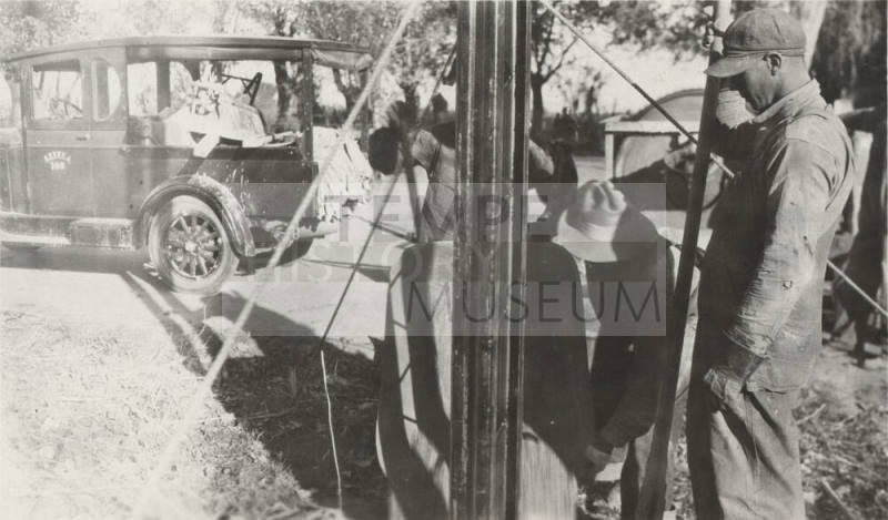 Men pouring cement to set power line steel poles