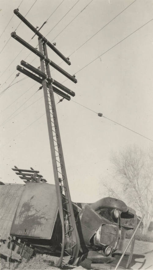 Overturned truck after colliding with power line pole