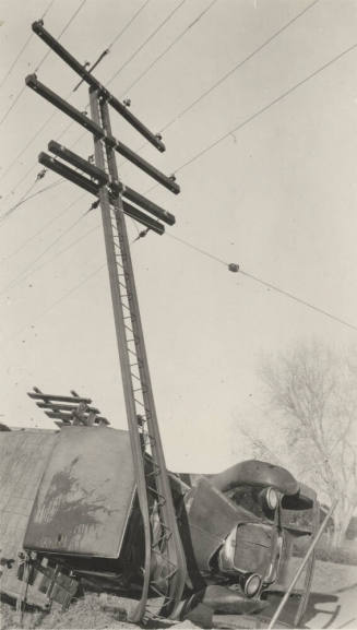 Overturned truck after colliding with power line pole