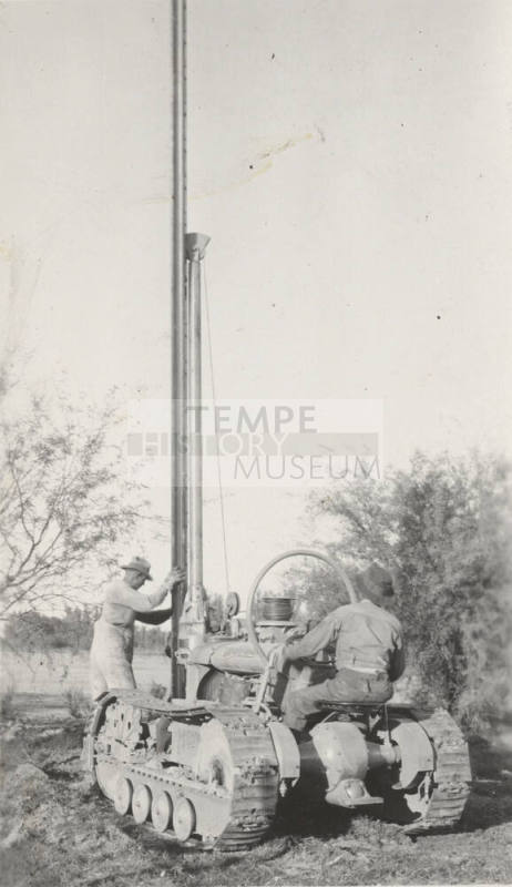 Photo-Men operating a pole hole digging machine
