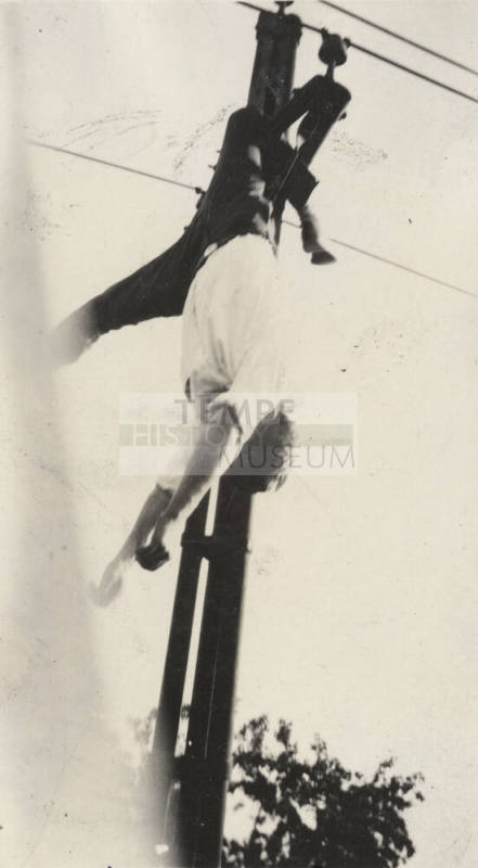 Photo- View of male suicide victim hanging from power line
