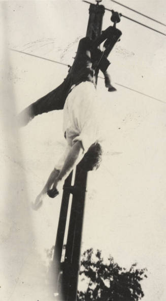 Photo- View of male suicide victim hanging from power line