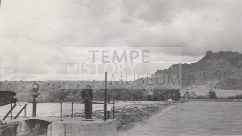 Photo- Man viewing the Salt River flowing over the Granite Reef Diversion Dam