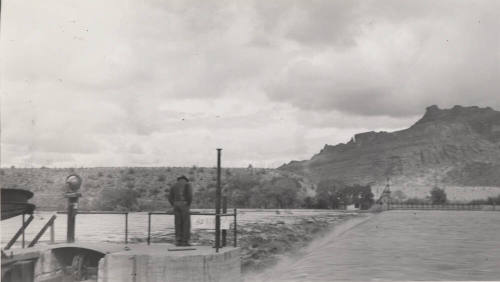 Photo- Man viewing the Salt River flowing over the Granite Reef Diversion Dam