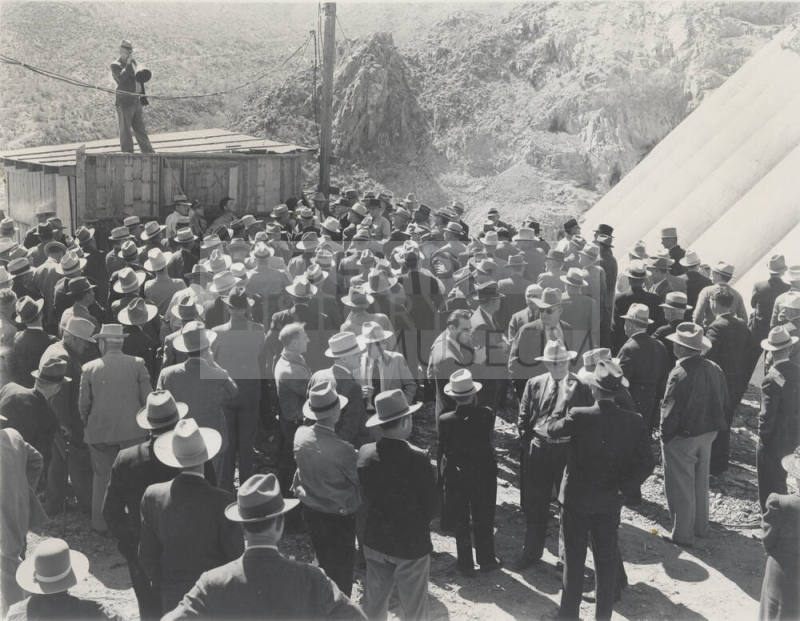 Photo- View of a man speaking to a large group of people at Bartlett Dam