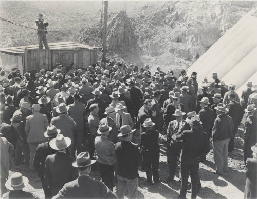 Photo- View of a man speaking to a large group of people at Bartlett Dam