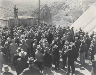Photo- View of a man speaking to a large group of people at Bartlett Dam