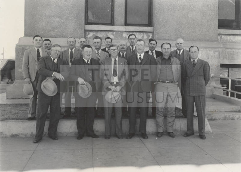 Photo- View of sixteen unidentified men standing in front of a building