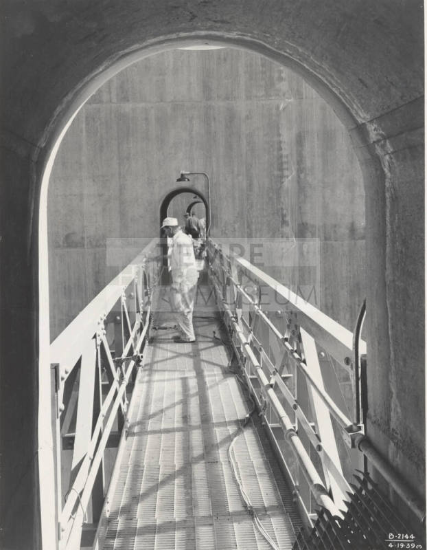 Photo- View of workers painting catwalk on Bartlett Dam