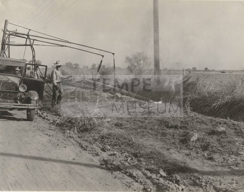 Photo- View of a three man crew with truck burning weeds along side of the road