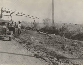 Photo- View of a three man crew with truck burning weeds along side of the road