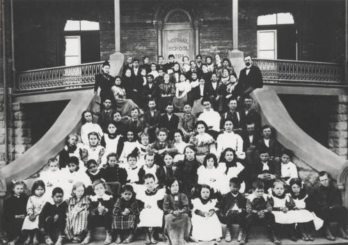 Elementary school children and faculty on "Old Main" front stairs