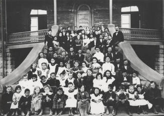 Elementary school children and faculty on "Old Main" front stairs