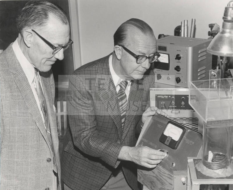 Dr. John Decker demonstrates his photosynthesis measuring device to Dr. Ira Judd