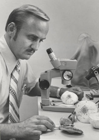 Dr. Chester R. Leathers, Associate Professor of Botany - Microbiology examines