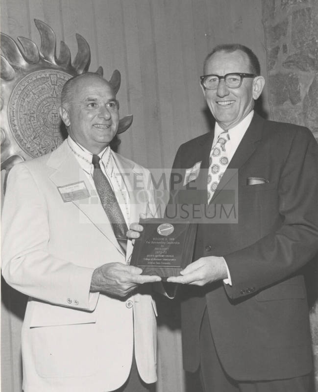 Dean Glenn D. Overman, College of Business Administration, presents plaque