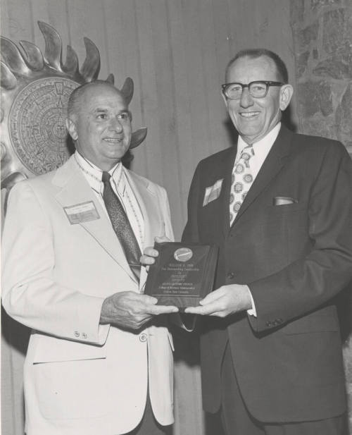Dean Glenn D. Overman, College of Business Administration, presents plaque