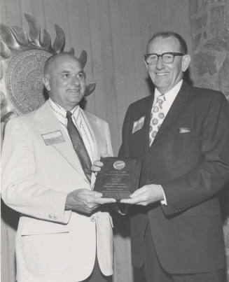 Dean Glenn D. Overman, College of Business Administration, presents plaque