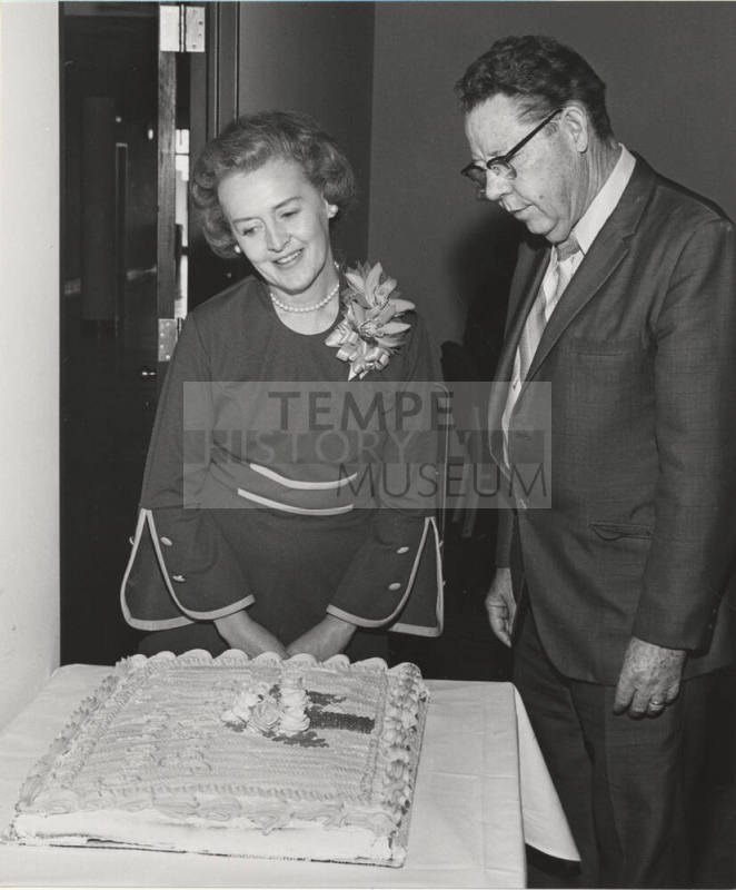 V.P. Gilbert Cady stands in front of cake for Mrs. Keith Rhodes, retired