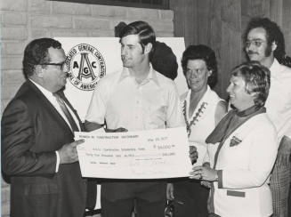 Carl Miller accepts a $34,000 check for the A.S.U. construction scholarship fund
