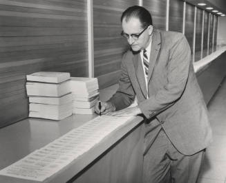Alfred Thomas Jr., signing diplomas for 1960 class