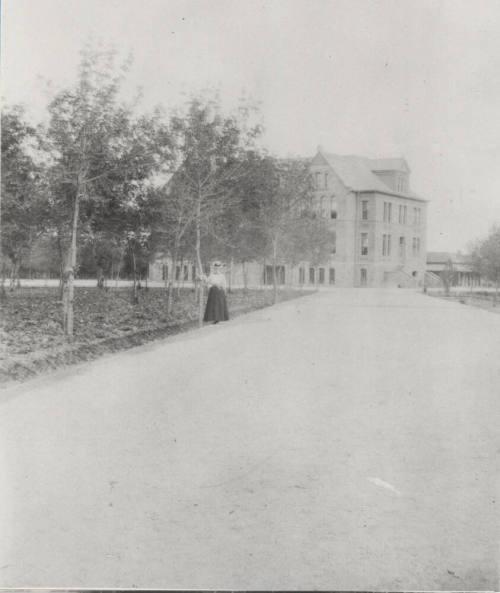 Woman Student Poses on Northwest Drive in Front of Old Main