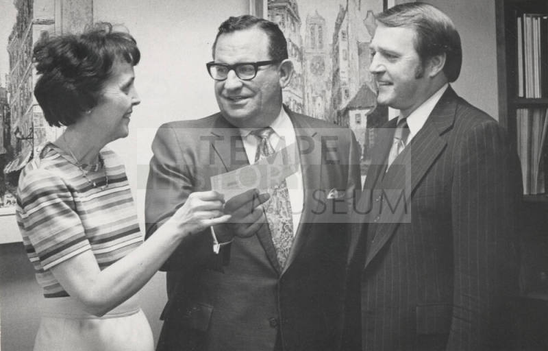 Dr. Miller Receives Check from Vivienne Gardner as Warren Summer Observes